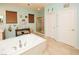 Bright bathroom featuring a soaking tub, separate shower, double doors and earth tone tile floors at 1017 Fairbury St, Henderson, NV 89052