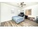 Cozy bedroom featuring wood-look floors, a ceiling fan, and a well-lit desk area at 1017 Fairbury St, Henderson, NV 89052
