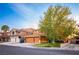 Suburban house with three car garage, desert landscaping, and mature trees in a well maintained community at 1017 Fairbury St, Henderson, NV 89052