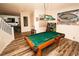 Finished basement with billiards table, an arcade game, and wood laminate floors at 1017 Fairbury St, Henderson, NV 89052