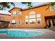 Backyard view featuring a private pool and an orange house with multiple windows at 1017 Fairbury St, Henderson, NV 89052