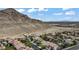 Stunning aerial view of the community with mountain views and a glimpse of the city skyline in the distance at 10385 Grassyrock Ct, Las Vegas, NV 89129