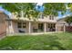 Backyard showcasing a covered patio, lush lawn, and mature trees, perfect for outdoor enjoyment and relaxing at 10385 Grassyrock Ct, Las Vegas, NV 89129