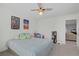 Well-lit bedroom with neutral carpet, ceiling fan and playful wall decor at 10385 Grassyrock Ct, Las Vegas, NV 89129