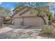 Three-car garage with spacious driveway enhanced by trees offering ample parking and curb appeal at 10385 Grassyrock Ct, Las Vegas, NV 89129