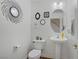 Stylish half bathroom boasting modern fixtures, decorative mirror, and pedestal sink at 10385 Grassyrock Ct, Las Vegas, NV 89129