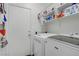 Laundry area featuring white washer and dryer, shelving, and storage space with a white door at 10385 Grassyrock Ct, Las Vegas, NV 89129