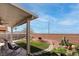 Enclosed backyard featuring an outdoor covered patio, desert landscaping and distant mountain views at 1141 Cactus Rock St, Henderson, NV 89011