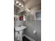 Sleek powder room with a pedestal sink, decorative mirror, and contemporary lighting at 1141 Cactus Rock St, Henderson, NV 89011