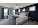 Stylish bedroom with a tufted headboard, dark accent wall, and plenty of natural light at 1141 Cactus Rock St, Henderson, NV 89011