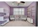 Brightly lit bedroom with neutral carpet, decorative shelving, and plush chairs at 1141 Cactus Rock St, Henderson, NV 89011