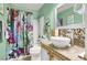 Bright bathroom featuring a unique vessel sink, decorative mirror, and colorful shower curtain at 1229 Swanbrooke Dr, Las Vegas, NV 89144