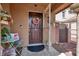 Inviting front porch with decorated front door with a wreath and seating area at 1229 Swanbrooke Dr, Las Vegas, NV 89144