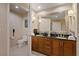 Bright bathroom with a double sink vanity with black countertop and white fixtures at 125 E Harmon Ave # 2318, Las Vegas, NV 89109