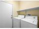Functional laundry room with washer, dryer, and shelving for storage at 1307 Bayleaf Terrace Ave, Henderson, NV 89014