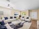 Staged living room with modern furniture, plush carpeting, large windows, and a ceiling fan at 1307 Bayleaf Terrace Ave, Henderson, NV 89014