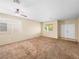 Spacious living room featuring neutral walls, plush carpeting, large windows, and a ceiling fan at 1307 Bayleaf Terrace Ave, Henderson, NV 89014