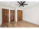 Empty bedroom with hardwood floors, ceiling fan, and multiple closet doors at 1404 Santa Margarita St # D, Las Vegas, NV 89146