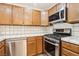 Close-up of the kitchen showcasing stainless steel appliances, and tile countertops at 1404 Santa Margarita St # D, Las Vegas, NV 89146
