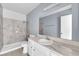 Modern bathroom with a bathtub and shower, marbled tile surround, and a large mirror at 1440 Vegas Valley Dr # 14, Las Vegas, NV 89169