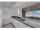 A bright kitchen featuring white cabinets, granite countertops, and a double sink under a window at 1440 Vegas Valley Dr # 14, Las Vegas, NV 89169