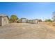 Exterior shot of a property featuring a gravel yard, a detached garage, and a small outbuilding at 1911 Jarvis Rd, Pahrump, NV 89060