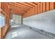 Interior view of a garage in progress with an unfinished ceiling and access to a rolling door at 1911 Jarvis Rd, Pahrump, NV 89060