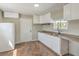 Compact kitchen featuring white cabinets, granite countertops, double sink, and linoleum flooring at 1911 Jarvis Rd, Pahrump, NV 89060
