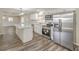 Bright kitchen features stainless appliances, white cabinetry, and an island with white countertop at 1911 Jarvis Rd, Pahrump, NV 89060
