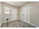 Mud room with gray laminate flooring, two entry doors, and a window at 1911 Jarvis Rd, Pahrump, NV 89060