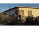 Side view of a quaint single-story home with weathered siding and foliage at 203 W Pacific Ave, Henderson, NV 89015