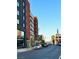 Street view of modern buildings and parked cars under a clear blue sky at 203 W Pacific Ave, Henderson, NV 89015