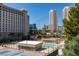 A community shot showcases the tennis courts, swimming pool and nearby buildings with clear sky at 205 E Harmon Ave # 511, Las Vegas, NV 89169