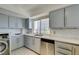 Cozy kitchen featuring grey cabinets, stainless steel appliances, and bright window at 205 E Harmon Ave # 511, Las Vegas, NV 89169