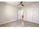 Neutral bedroom with tile floors, ceiling fan, door, and double door closet at 2073 Paterno Ave, Las Vegas, NV 89123