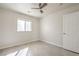 Clean bedroom with tile flooring, a window with blinds, ceiling fan, and a door at 2073 Paterno Ave, Las Vegas, NV 89123