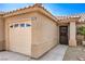 Close-up of home's garage and front door, complemented by desert landscaping and concrete walkway at 2073 Paterno Ave, Las Vegas, NV 89123