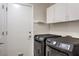Laundry room with newer washer and dryer units, a door to the outside, and upper cabinets at 2073 Paterno Ave, Las Vegas, NV 89123