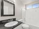 Well-lit bathroom features a modern vanity with a granite countertop, framed mirror, and tiled shower-tub combination at 2315 Opponents Ridge St, North Las Vegas, NV 89032