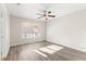 Bedroom with ceiling fan, natural light, and modern gray wood flooring at 2315 Opponents Ridge St, North Las Vegas, NV 89032