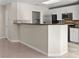 Modern kitchen featuring white cabinets, stainless steel appliances, and a breakfast bar area at 2315 Opponents Ridge St, North Las Vegas, NV 89032
