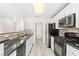 Well-lit kitchen featuring stainless steel appliances, tile backsplash, and dark countertops at 2315 Opponents Ridge St, North Las Vegas, NV 89032