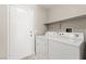 Functional laundry room featuring a side-by-side washer and dryer, ample shelving, and convenient access to the backyard at 2315 Opponents Ridge St, North Las Vegas, NV 89032