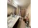 Bathroom vanity with dual sinks, shower, and tile floors at 2409 W Gilmore Ave, North Las Vegas, NV 89032
