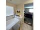 Bright bathroom featuring a built-in bathtub, large window and view into a bedroom at 2409 W Gilmore Ave, North Las Vegas, NV 89032