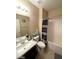 Bathroom includes a sink, mirror, toilet, shower and black and white shower curtain at 2409 W Gilmore Ave, North Las Vegas, NV 89032