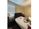 Bright bedroom featuring a window, nightstand, and bed at 2409 W Gilmore Ave, North Las Vegas, NV 89032
