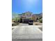 Inviting two-story home featuring desert landscaping, a brick driveway, and a two-car garage at 2409 W Gilmore Ave, North Las Vegas, NV 89032