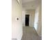 Neutral hallway with tiled floors leading to bedrooms and an exit door at 2409 W Gilmore Ave, North Las Vegas, NV 89032
