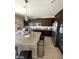 Spacious kitchen features a large island, stainless steel appliances, and ample dark wood cabinetry at 2409 W Gilmore Ave, North Las Vegas, NV 89032